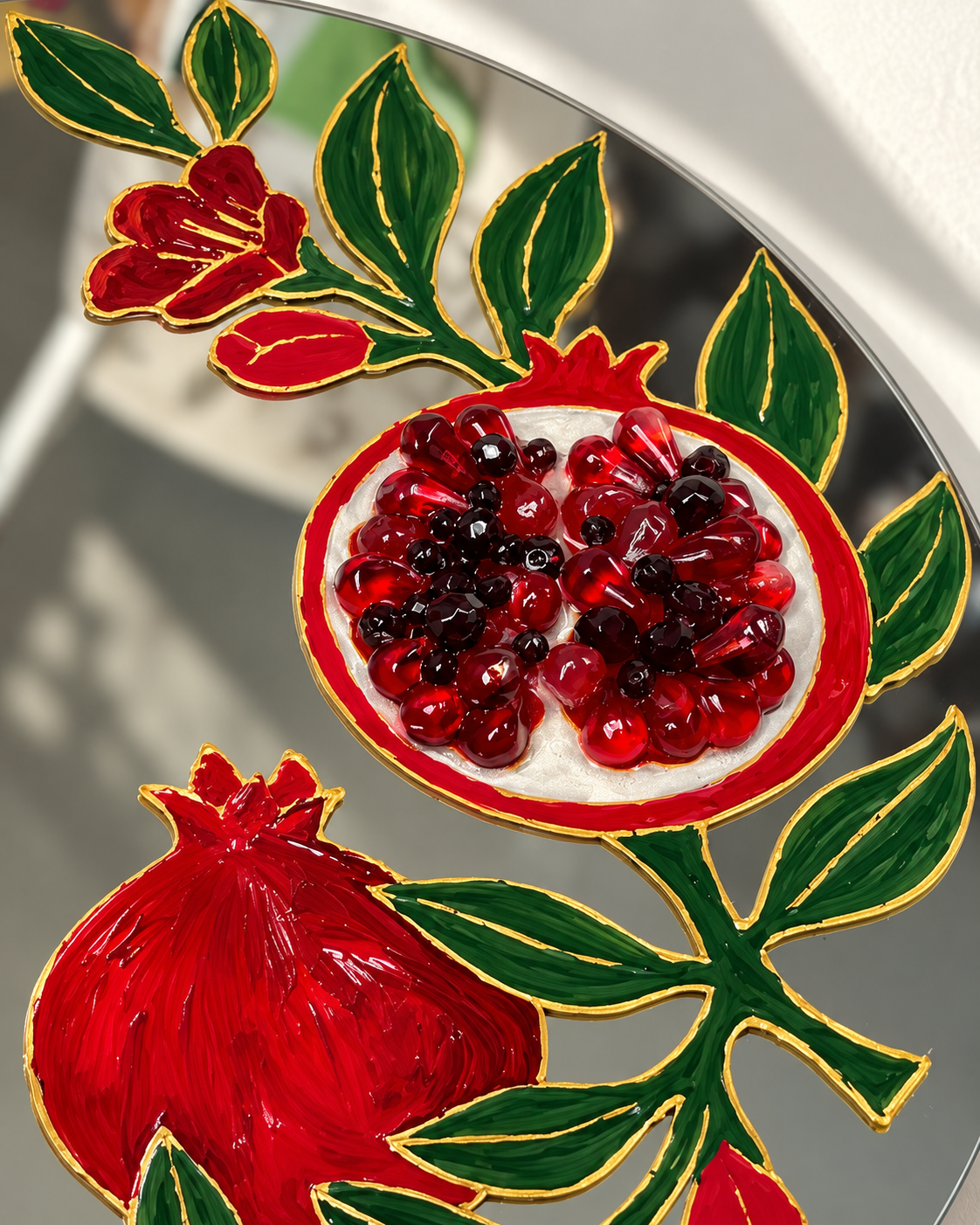 Detail of real hand-painted gold outlines and ruby resin seeds, photograph retouched